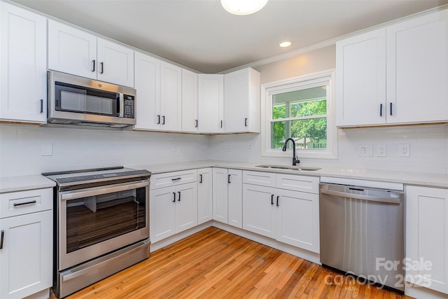 6007 Charing Pl, Charlotte, NC 28211 - kitchen featuring appliances with stainless steel finishes, a sink, light countertops, backsplash, and ornamental molding