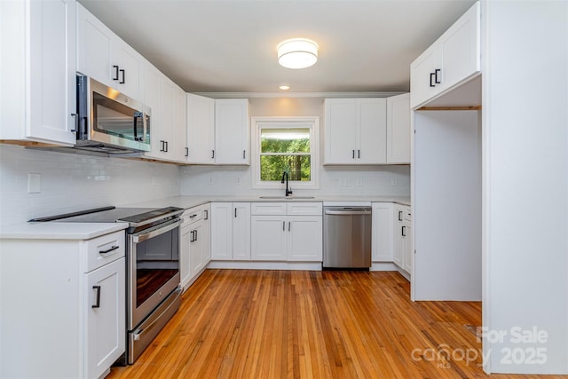 6007 Charing Pl, Charlotte, NC 28211 - kitchen with stainless steel appliances, a sink, decorative backsplash, light countertops, and light wood finished floors