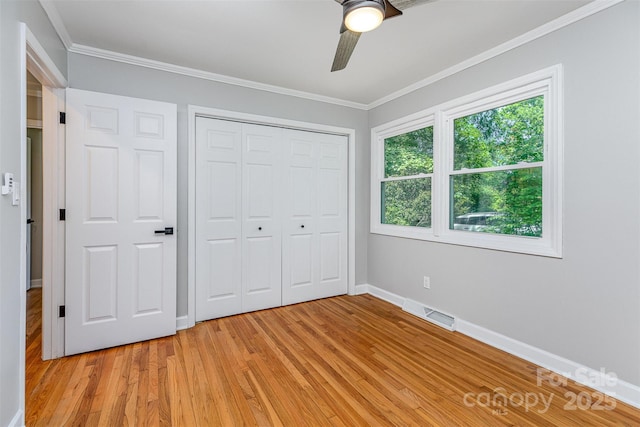 6007 Charing Pl, Charlotte, NC 28211 - unfurnished bedroom featuring baseboards, light wood-style floors, crown molding, a closet, and a ceiling fan