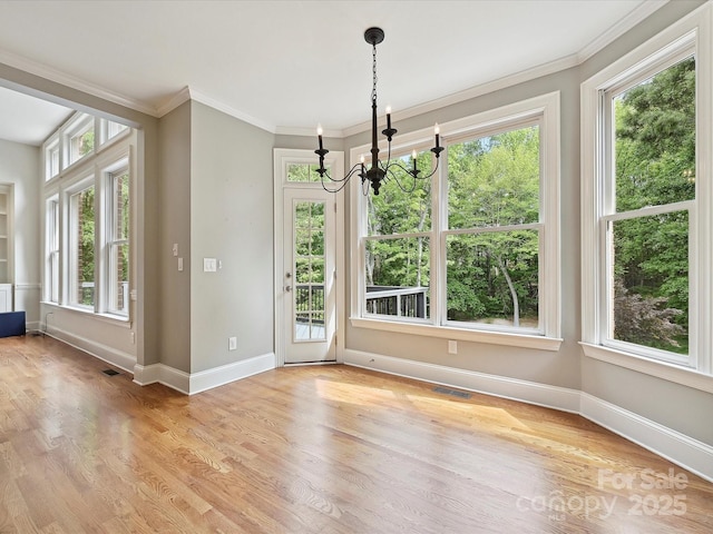 unfurnished dining area featuring an inviting chandelier, baseboards, and a healthy amount of sunlight