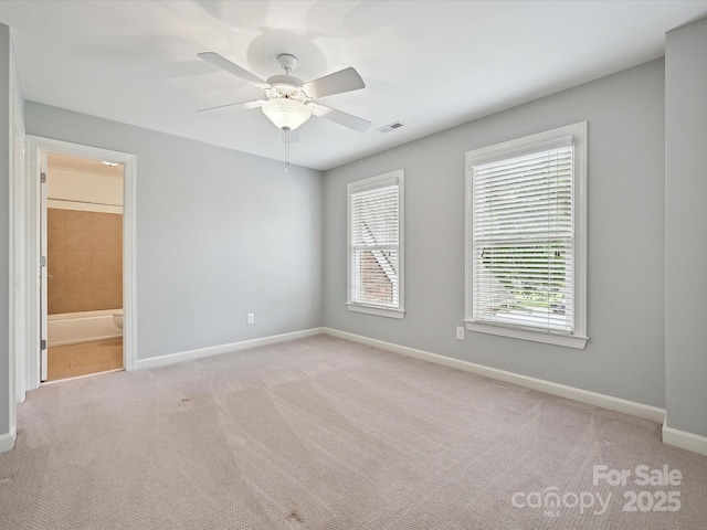 unfurnished bedroom featuring a ceiling fan, baseboards, visible vents, and light carpet