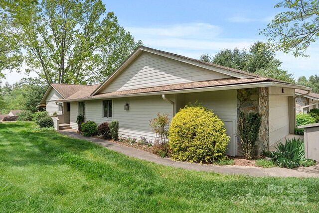 120 Cloverleaf Ln, Asheville, NC 28803 - view of home's exterior featuring an attached garage, a lawn, roof with shingles, and stone siding