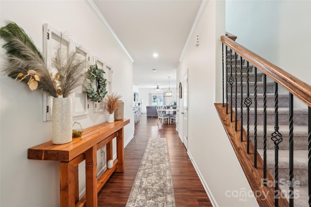 corridor with crown molding, baseboards, and stairs