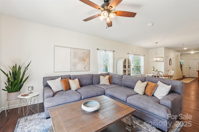 living area with baseboards, ceiling fan, and wood finished floors