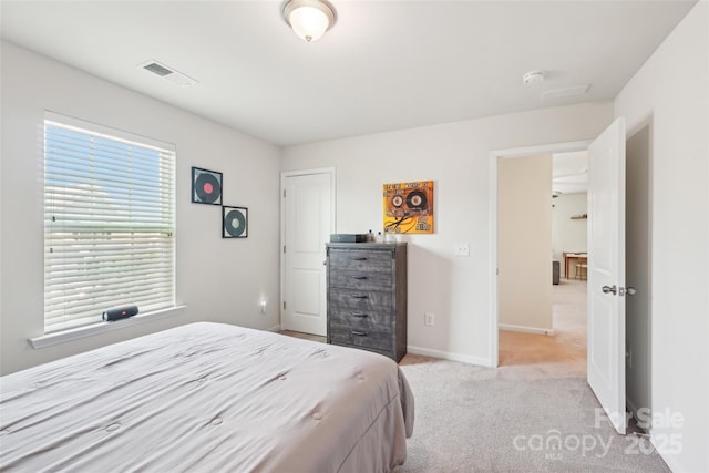 bedroom featuring baseboards, visible vents, and light carpet