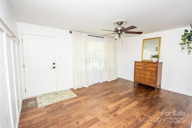 interior space featuring baseboards, ceiling fan, wood finished floors, and visible vents