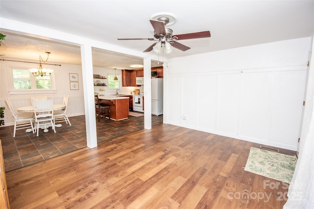 living room with wood finished floors and ceiling fan with notable chandelier