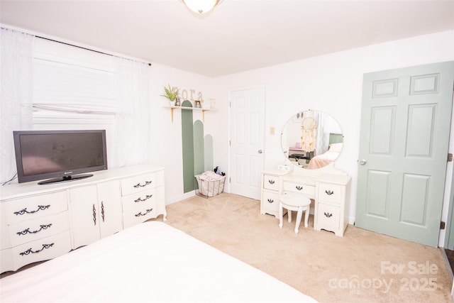 bedroom with baseboards and light carpet