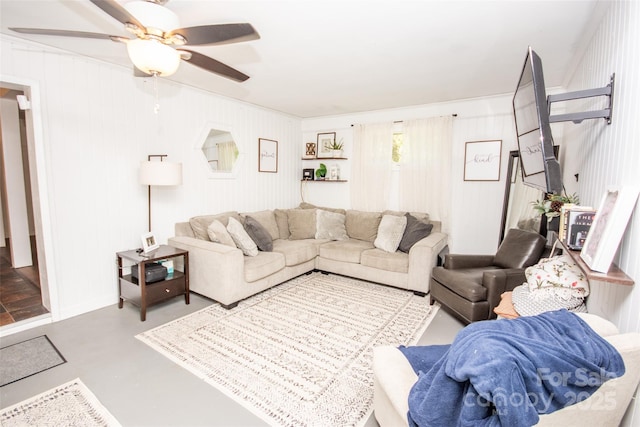 living area with finished concrete floors and a ceiling fan