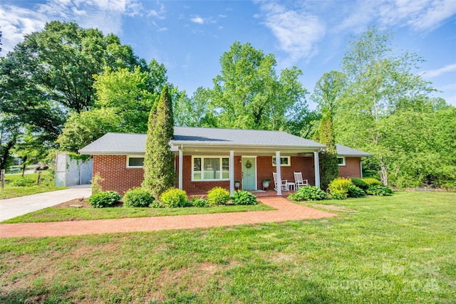 ranch-style home featuring a porch, brick siding, concrete driveway, and a front lawn