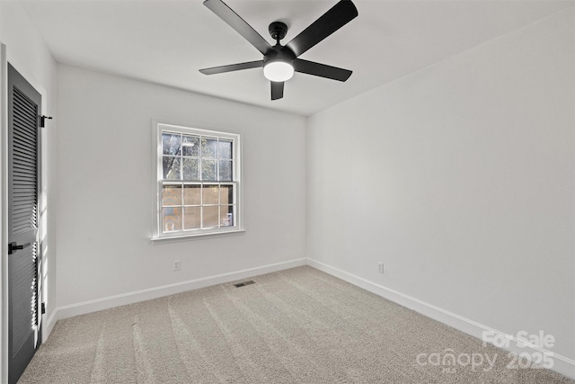 interior space featuring carpet floors, a ceiling fan, baseboards, and visible vents