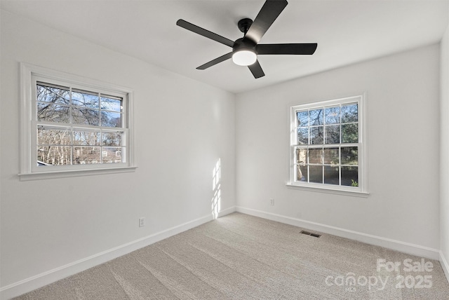unfurnished room featuring visible vents, baseboards, ceiling fan, and carpet floors