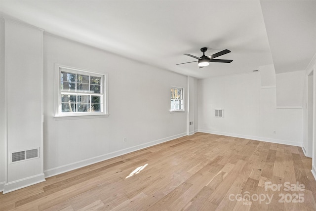 spare room with visible vents, a ceiling fan, light wood-style flooring, and baseboards