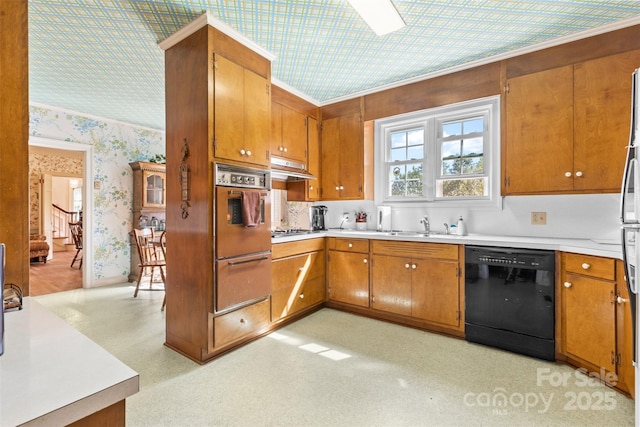 kitchen with brown cabinets, light countertops, black dishwasher, wallpapered walls, and oven