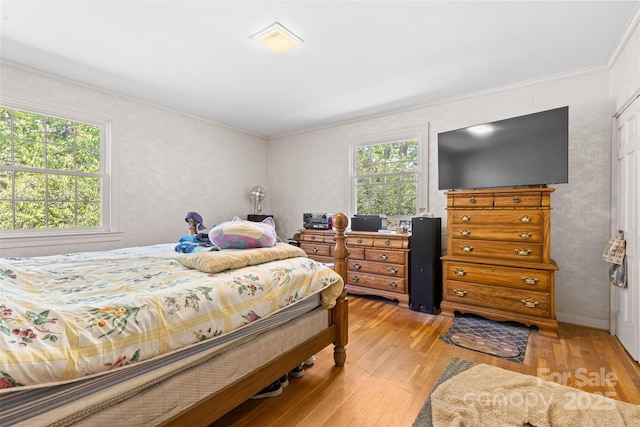 bedroom with light wood-type flooring and ornamental molding