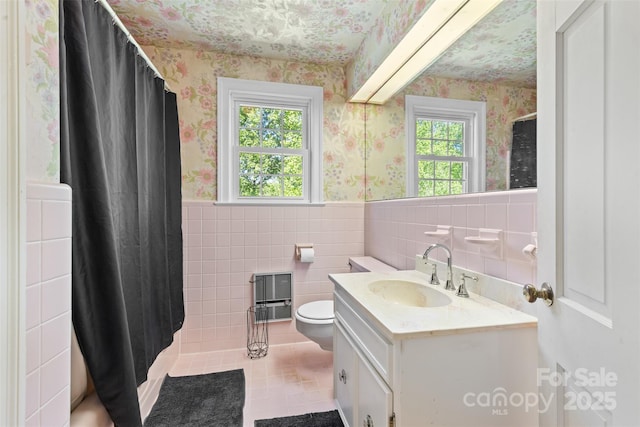bathroom with vanity, wainscoting, toilet, wallpapered walls, and tile patterned floors