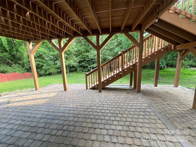view of patio with fence and stairway