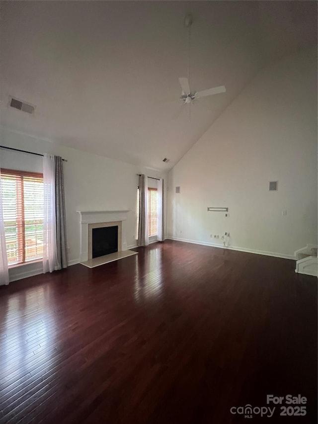 unfurnished living room featuring ceiling fan, visible vents, a fireplace, high vaulted ceiling, and dark wood-style floors