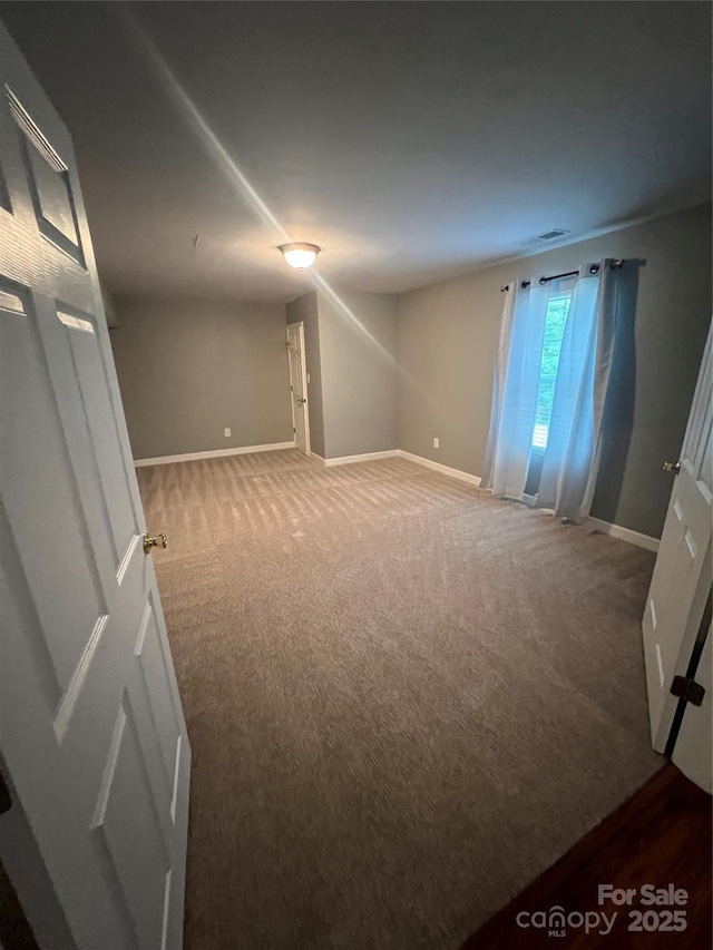 spare room with carpet floors and baseboards