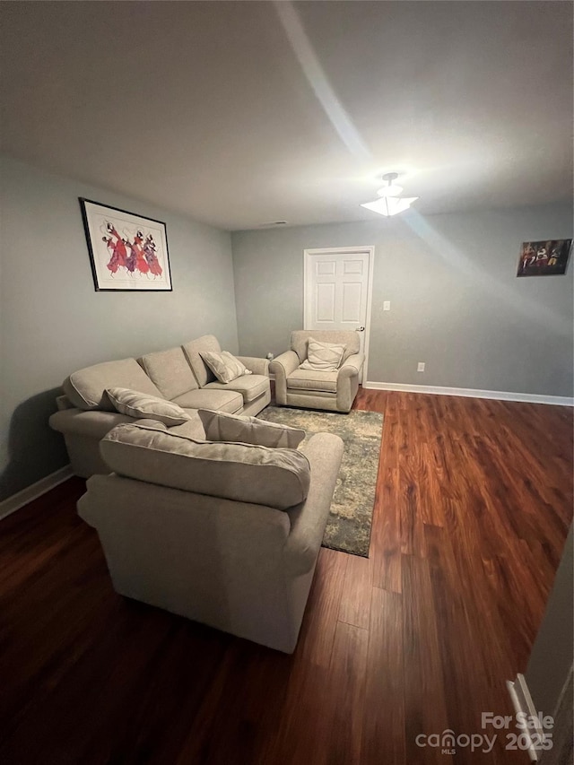 living room with baseboards, a ceiling fan, and dark wood-style flooring