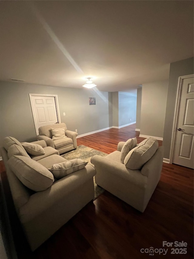 living room featuring baseboards and dark wood finished floors