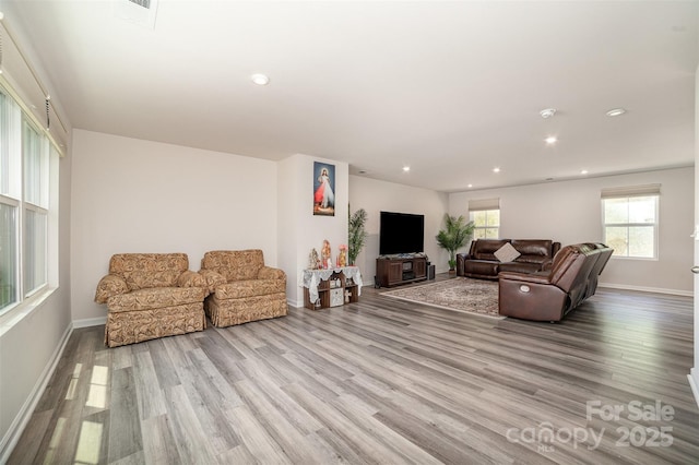 living room featuring recessed lighting, baseboards, and wood finished floors