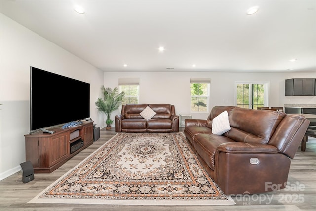 living area featuring recessed lighting, baseboards, and light wood-type flooring