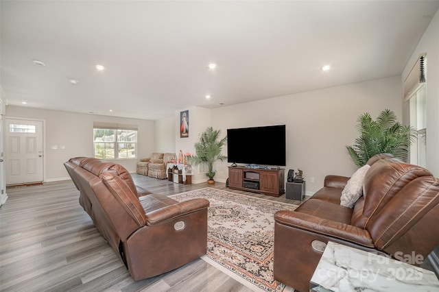 living room featuring recessed lighting, baseboards, and light wood-style floors