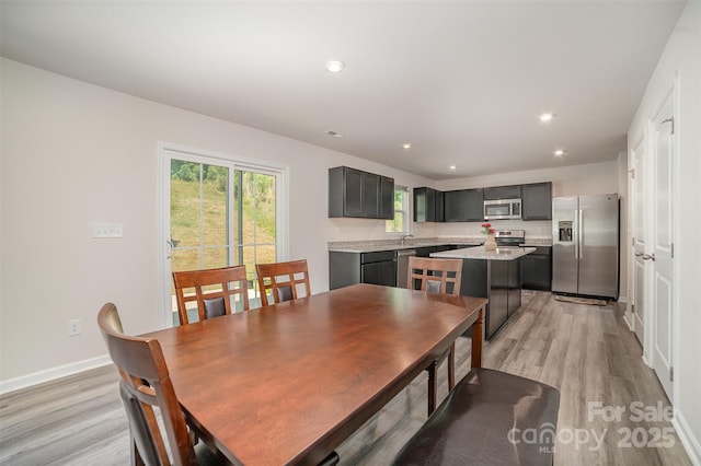 dining area featuring light wood-type flooring, recessed lighting, and baseboards