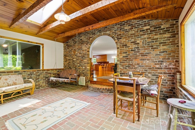 dining area with arched walkways, wood ceiling, and lofted ceiling with skylight