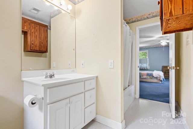 bathroom featuring vanity, tile patterned flooring, baseboards, ceiling fan, and shower / bath combo