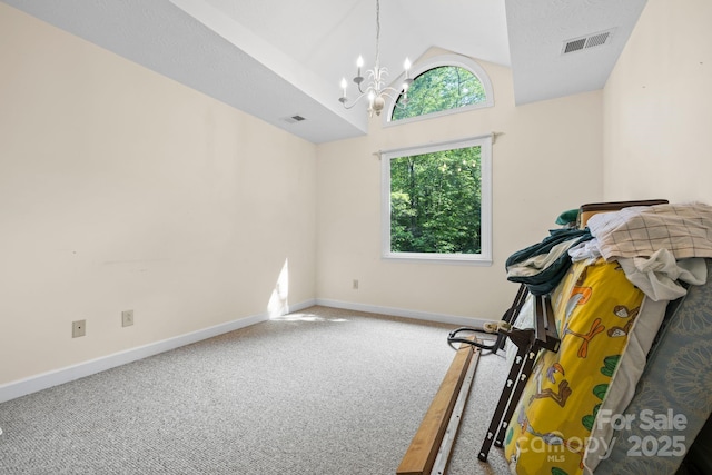 exercise area with visible vents, carpet flooring, a chandelier, and vaulted ceiling