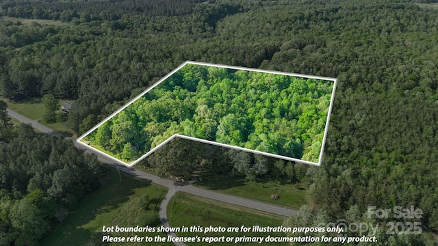 drone / aerial view with a wooded view