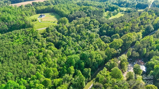 drone / aerial view with a wooded view