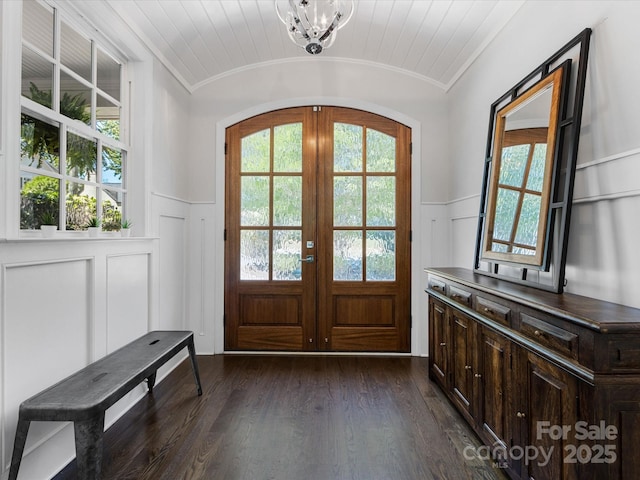 foyer with french doors, wainscoting, and a decorative wall