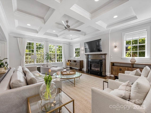 living area with ceiling fan, a fireplace with flush hearth, beam ceiling, wood finished floors, and coffered ceiling