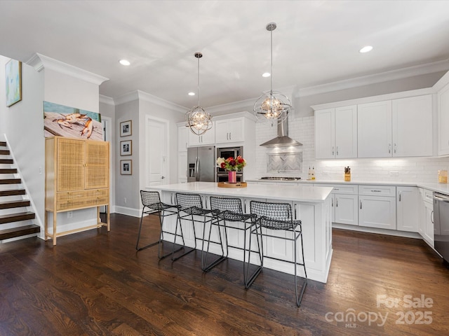 kitchen with crown molding, appliances with stainless steel finishes, light countertops, a kitchen breakfast bar, and backsplash