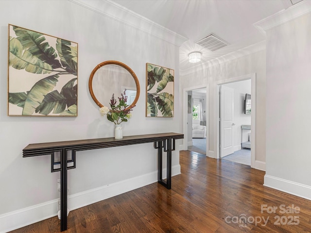corridor featuring baseboards, visible vents, ornamental molding, and wood finished floors