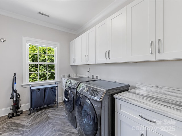 clothes washing area featuring cabinet space, crown molding, separate washer and dryer, baseboards, and visible vents