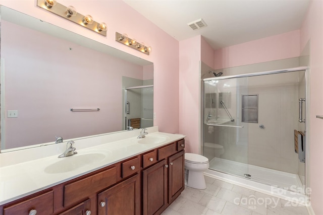 full bath featuring toilet, a shower stall, and double vanity
