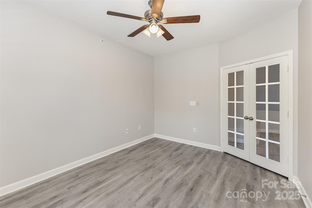 spare room with french doors, wood finished floors, baseboards, and a ceiling fan