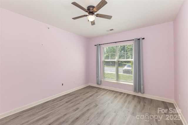 unfurnished room featuring light wood finished floors, baseboards, and a ceiling fan
