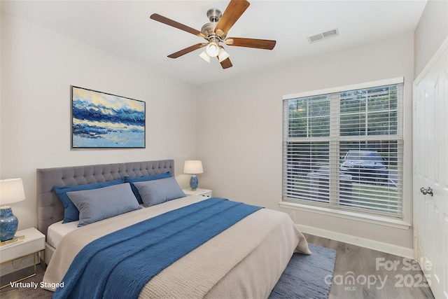 bedroom with wood finished floors, baseboards, and ceiling fan