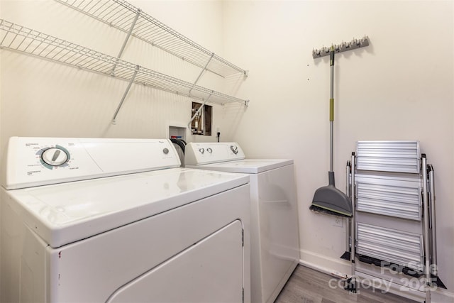 laundry room with radiator heating unit, washing machine and clothes dryer, baseboards, and wood finished floors