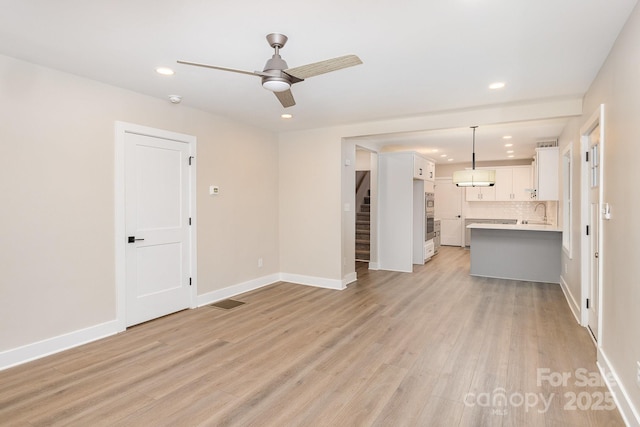 1208 Fordham Rd, Charlotte, NC 28208 - unfurnished living room with ceiling fan, recessed lighting, light wood-style floors, baseboards, and stairway