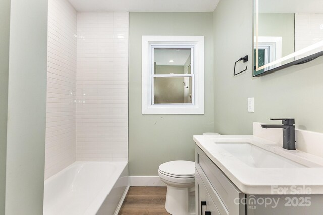 1208 Fordham Rd, Charlotte, NC 28208 - bathroom with wood finished floors, toilet, baseboards, vanity, and bathing tub / shower combination