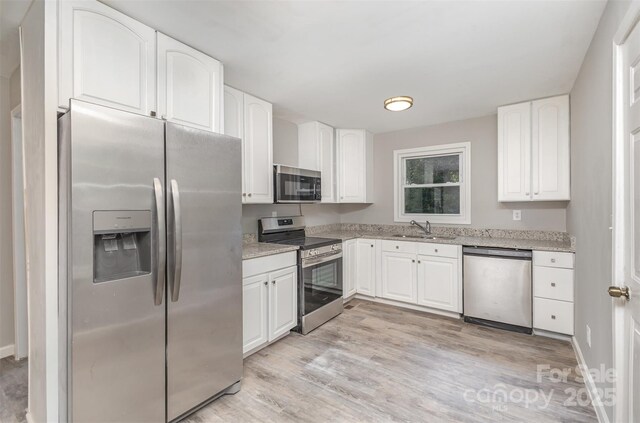 2603 Mary Ave, Gastonia, NC 28052 - kitchen with appliances with stainless steel finishes, a sink, light stone counters, and white cabinetry