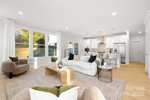 living room with crown molding, recessed lighting, and light wood-style flooring
