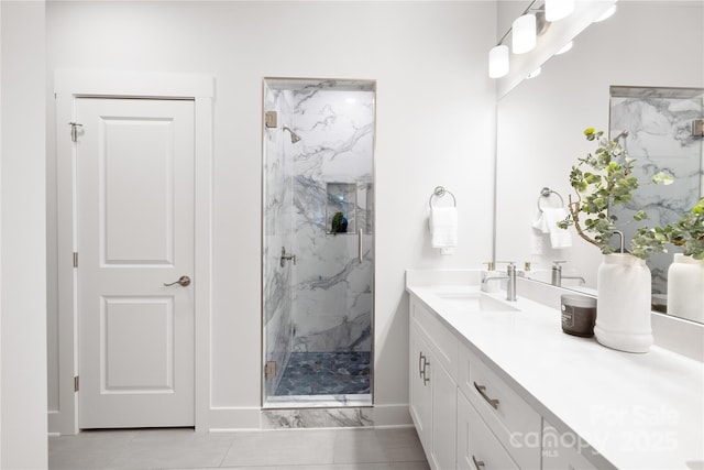 bathroom featuring baseboards, a marble finish shower, and vanity