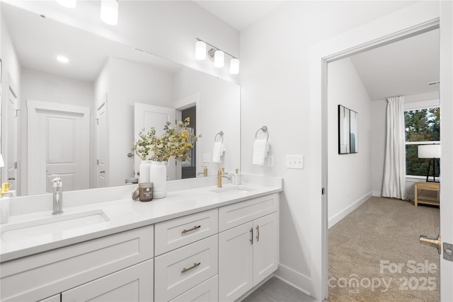 bathroom featuring baseboards, a sink, double vanity, and visible vents